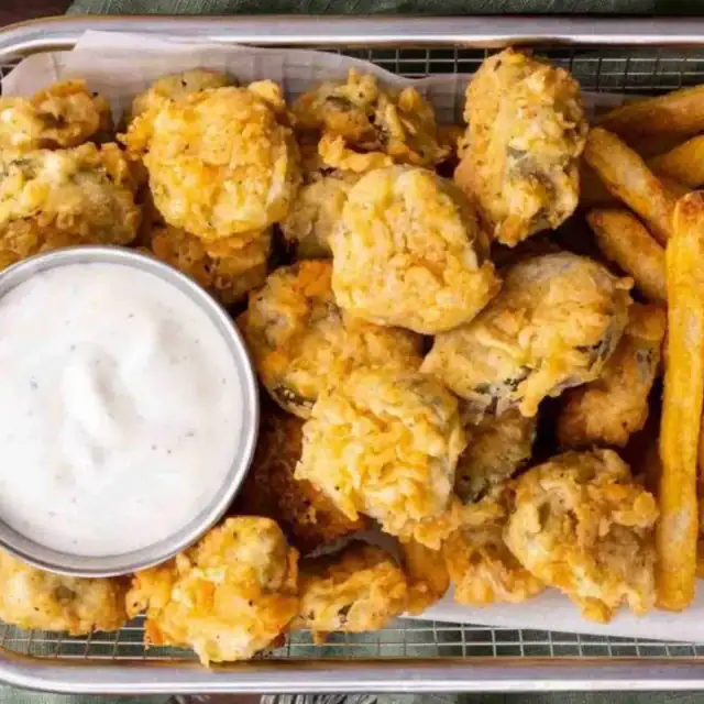 pickles in a basket with sauce and fries