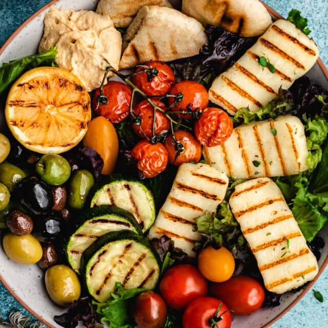 Appetizer plate filled with grilled vegetables, and cheese slices.
