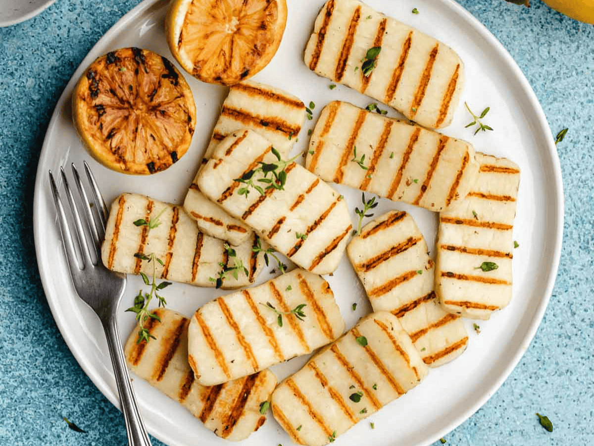 Firm cheese slices on plate with grill marks.