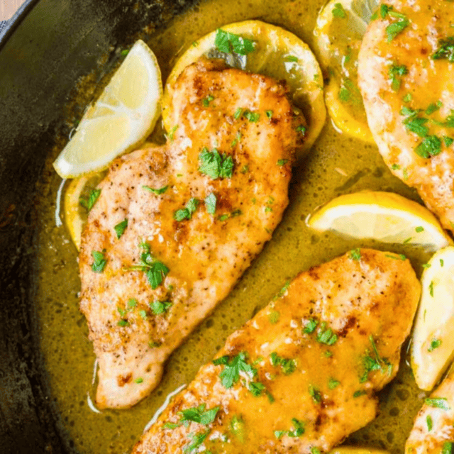 Chicken breast in skillet with lemon and herbs