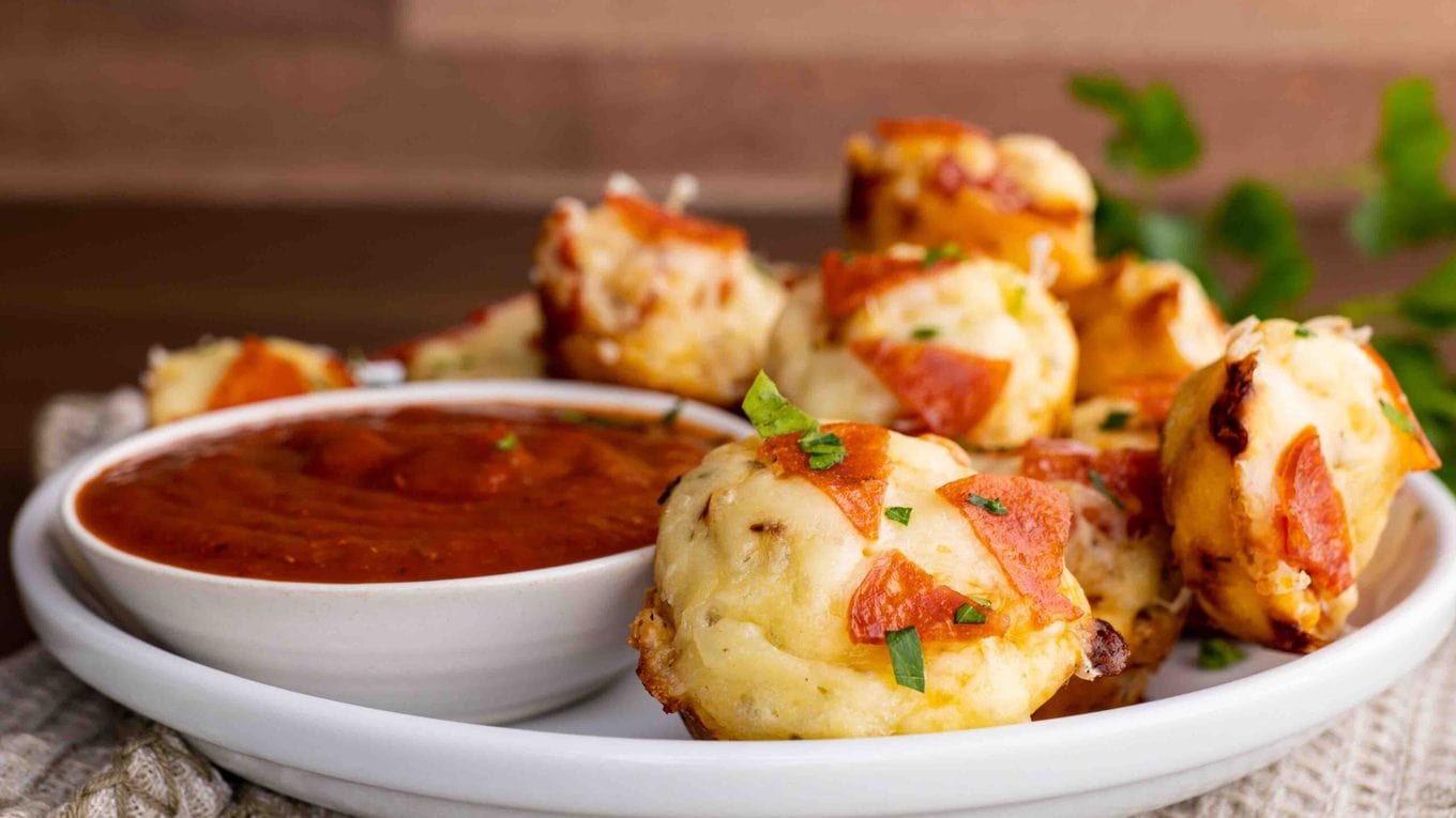 Pepperoni Pizza Bites on serving plate with marinara sauce