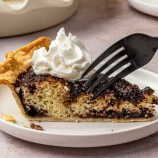 A slice of cake on a white plate with a fork