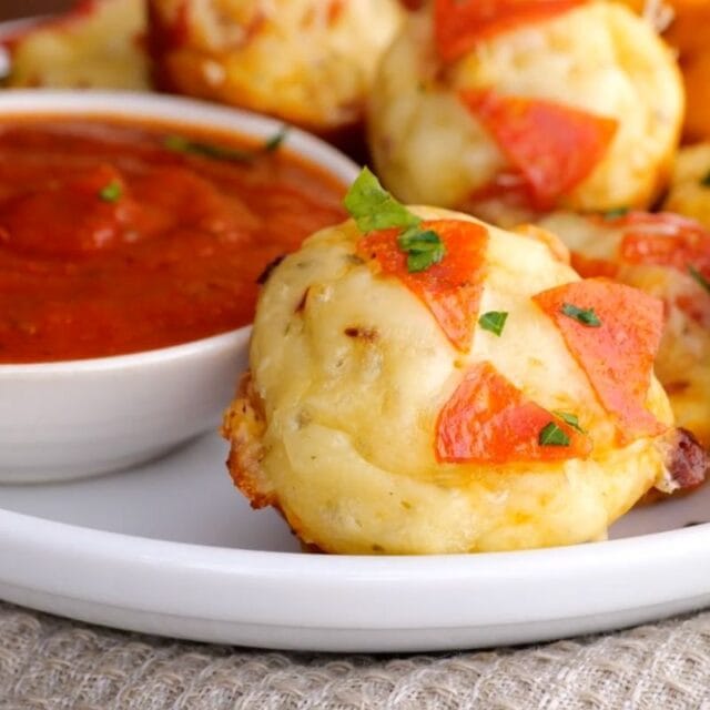 Pepperoni Pizza Bites on serving plate with marinara sauce