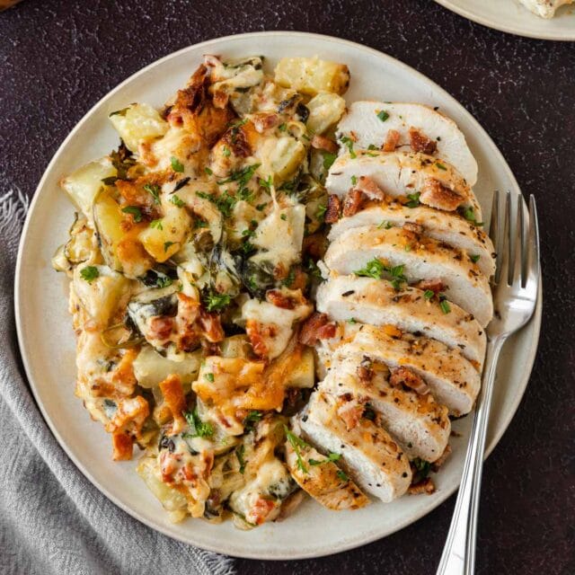Tuscan Bacon Gratin Potatoes plated with sliced chicken