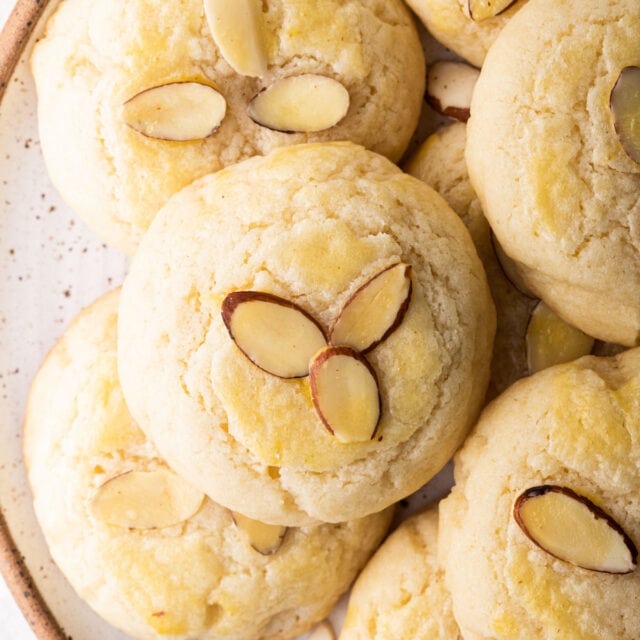 Almond cookies on a plate decorated with sliced almonds.