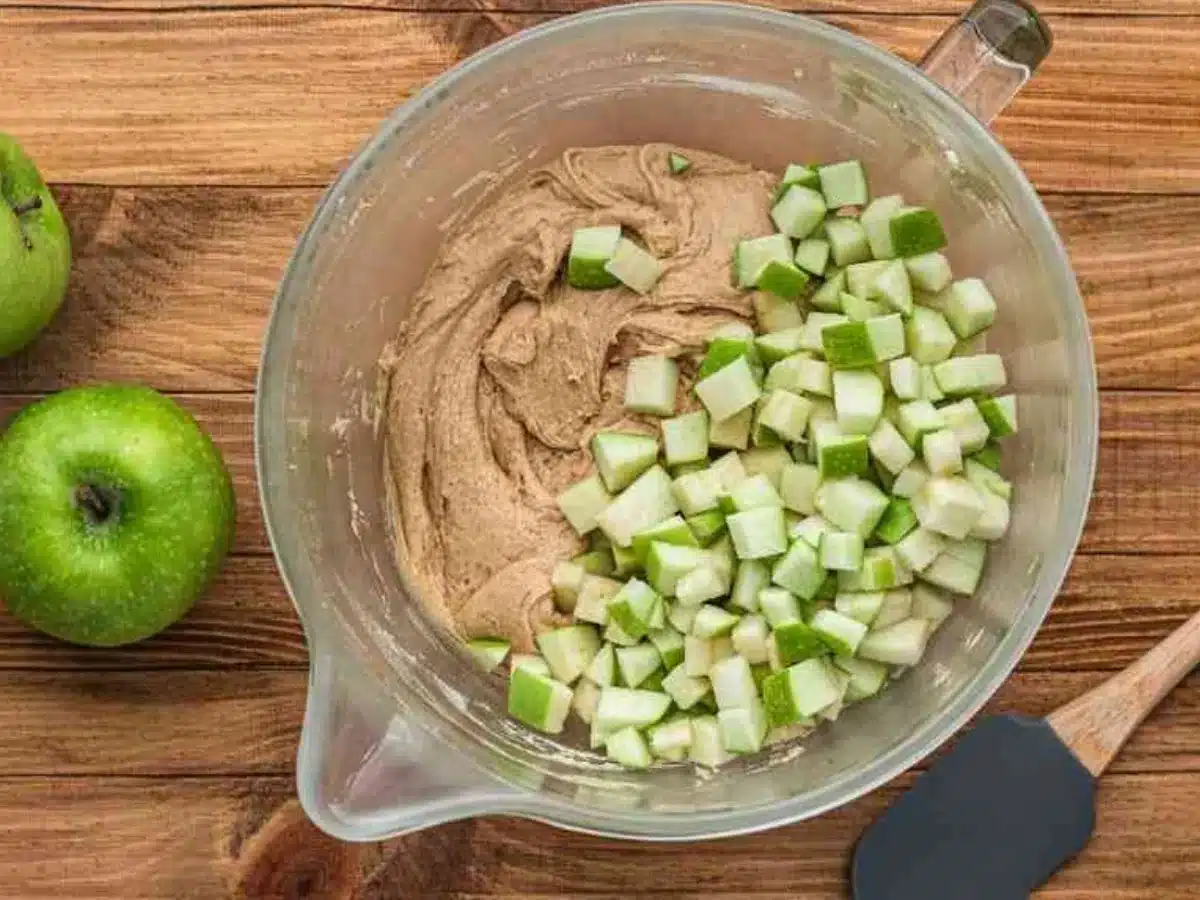 adding apples to mixing bowl 