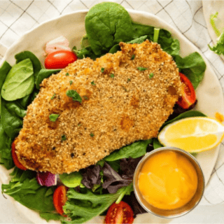 Chicken served on plate with dipping sauce and lemon