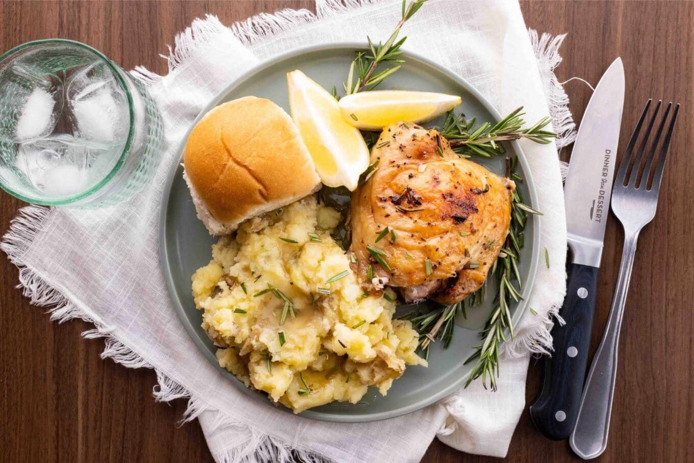 Baked Rosemary Chicken on plate with mashed potatoes and dinner roll