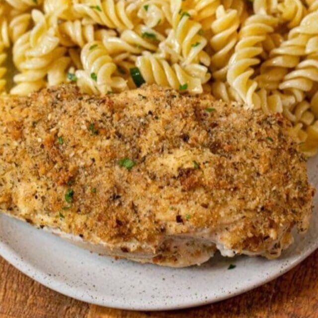 Chicken and pasta on a white [plate