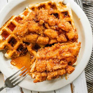 Crispy chicken served over waffle on a plate with a fork 4x3