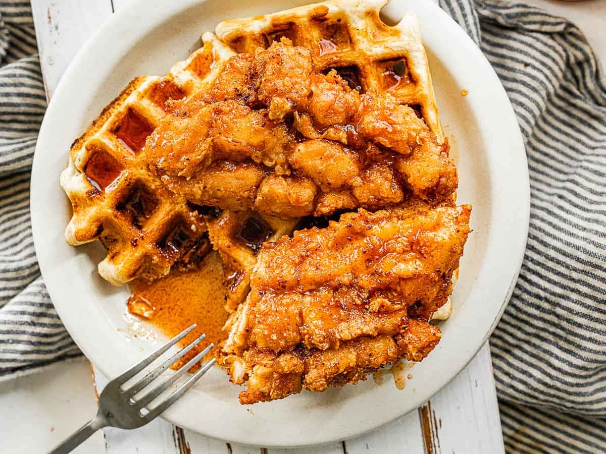 Crispy chicken served over waffle on a plate with a fork 4x3