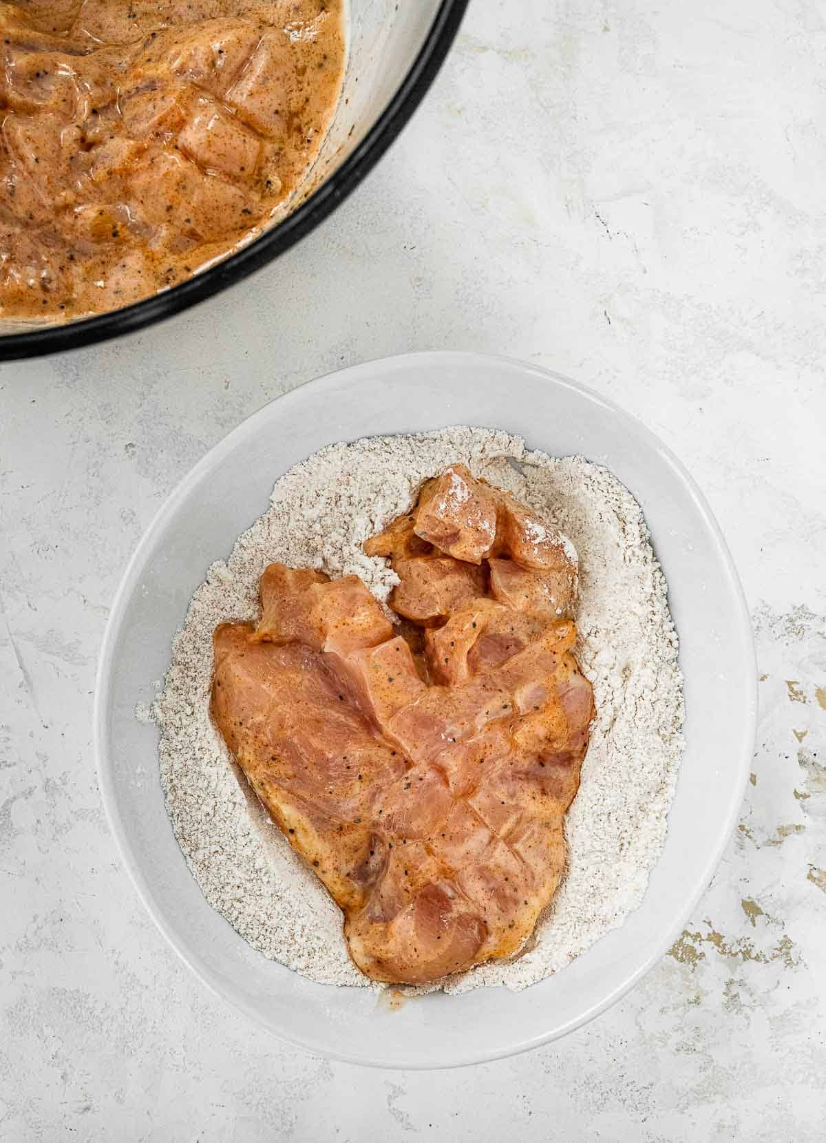 chicken in bowl with flour coating