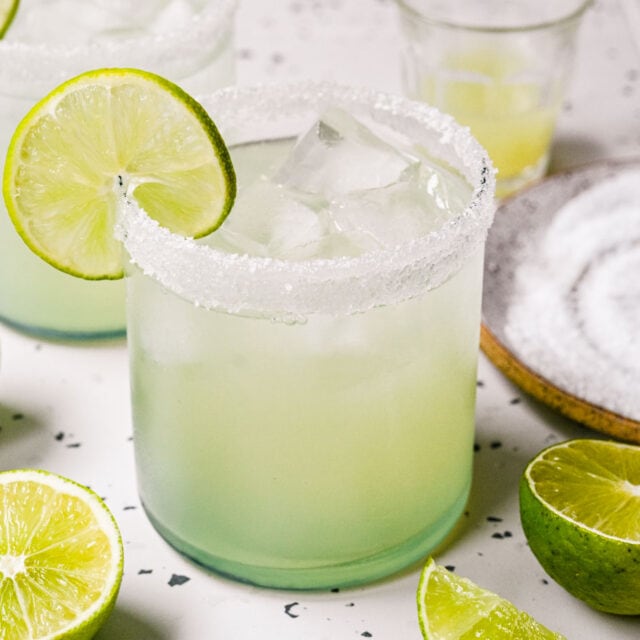 Mixed margarita in glass with ice and lime slice