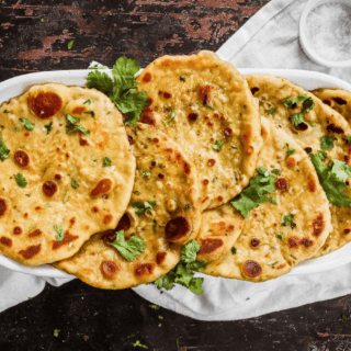 thin circular bread with green garnish on a platter