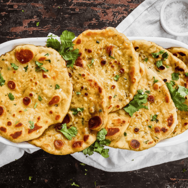 thin circular bread with green garnish on a platter