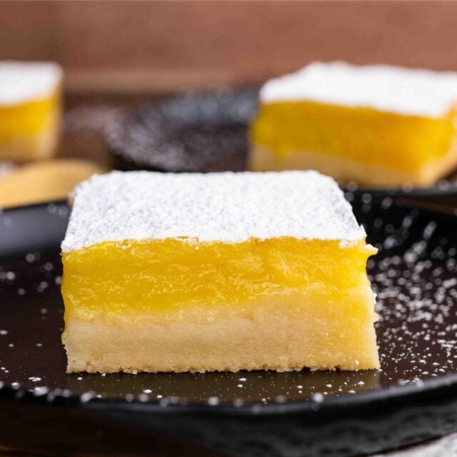 Lemon Bars square on plate with powdered sugar topping