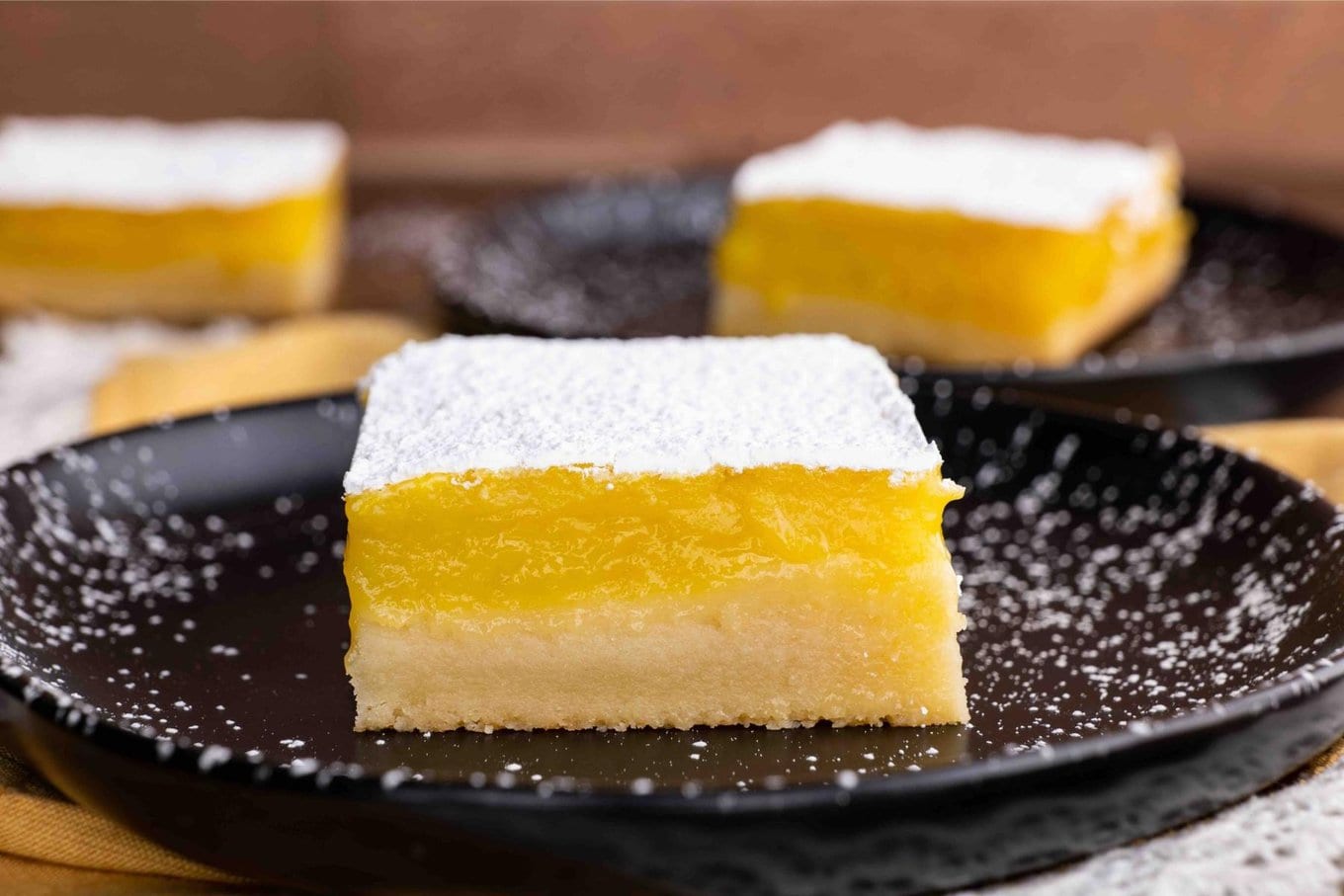 Lemon Bars square on plate with powdered sugar topping