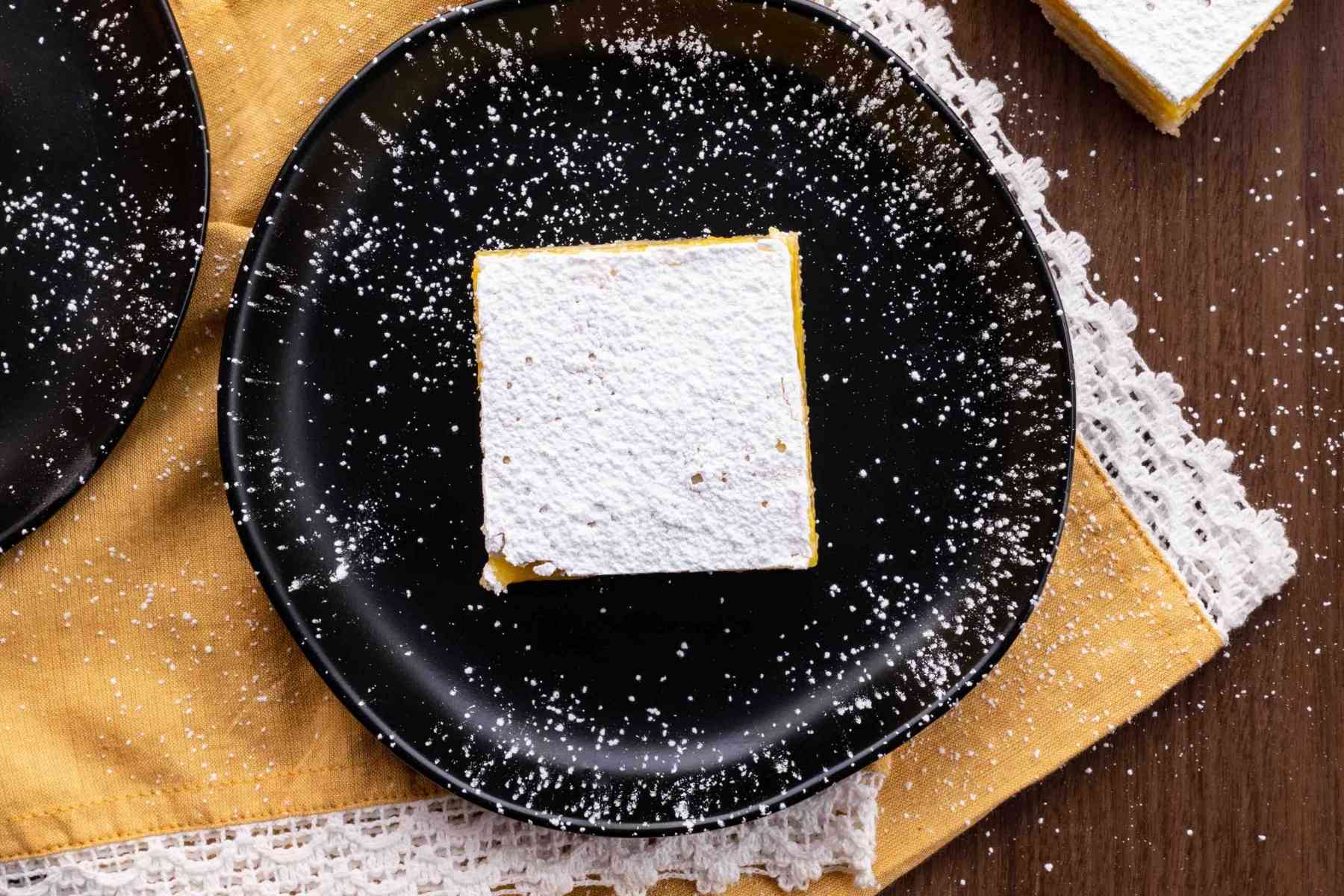 Lemon Bars square on plate with powdered sugar topping