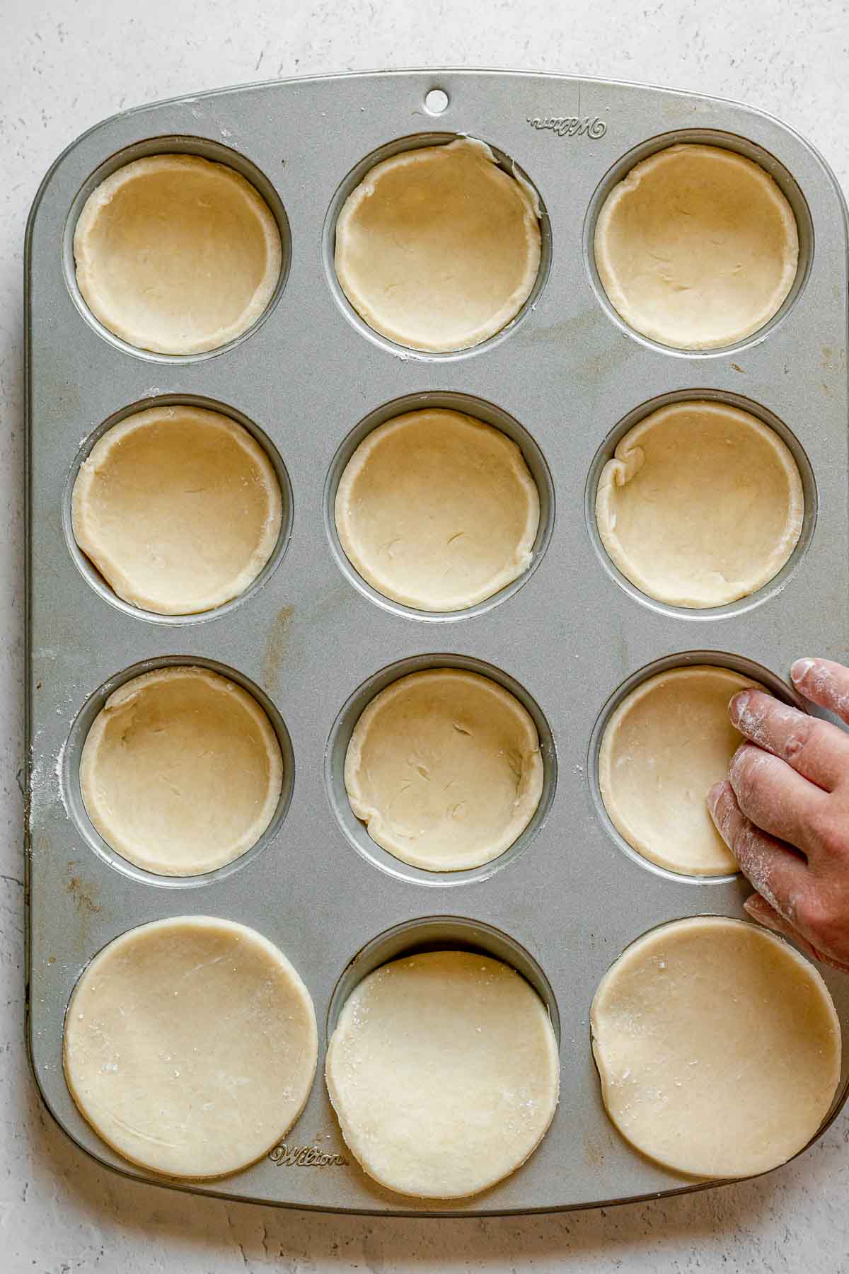 Pecan Butter Tarts pressing tart dough in muffin tin