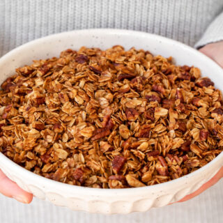 Holding granola in a white bowl 4x3