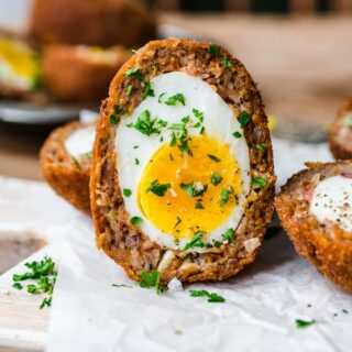 Scotch egg sliced in half vertically.