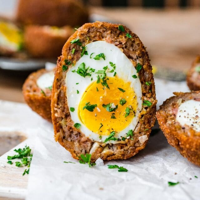 Scotch egg sliced in half vertically.