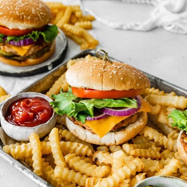 Chicken Burgers assembled burgers with crinkle fries on metal tray with cup of ketchup