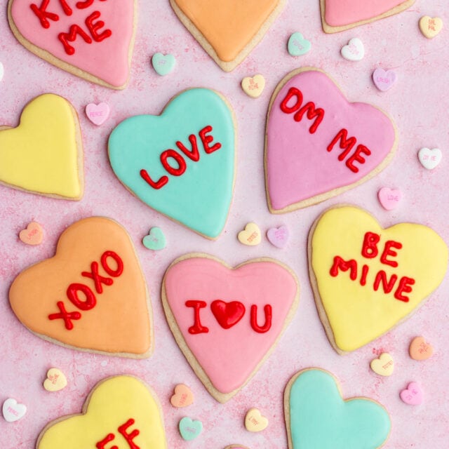 decorated heart shaped cookies with phrases like Love, XOXO, I*heart*U, DM, Be Mine