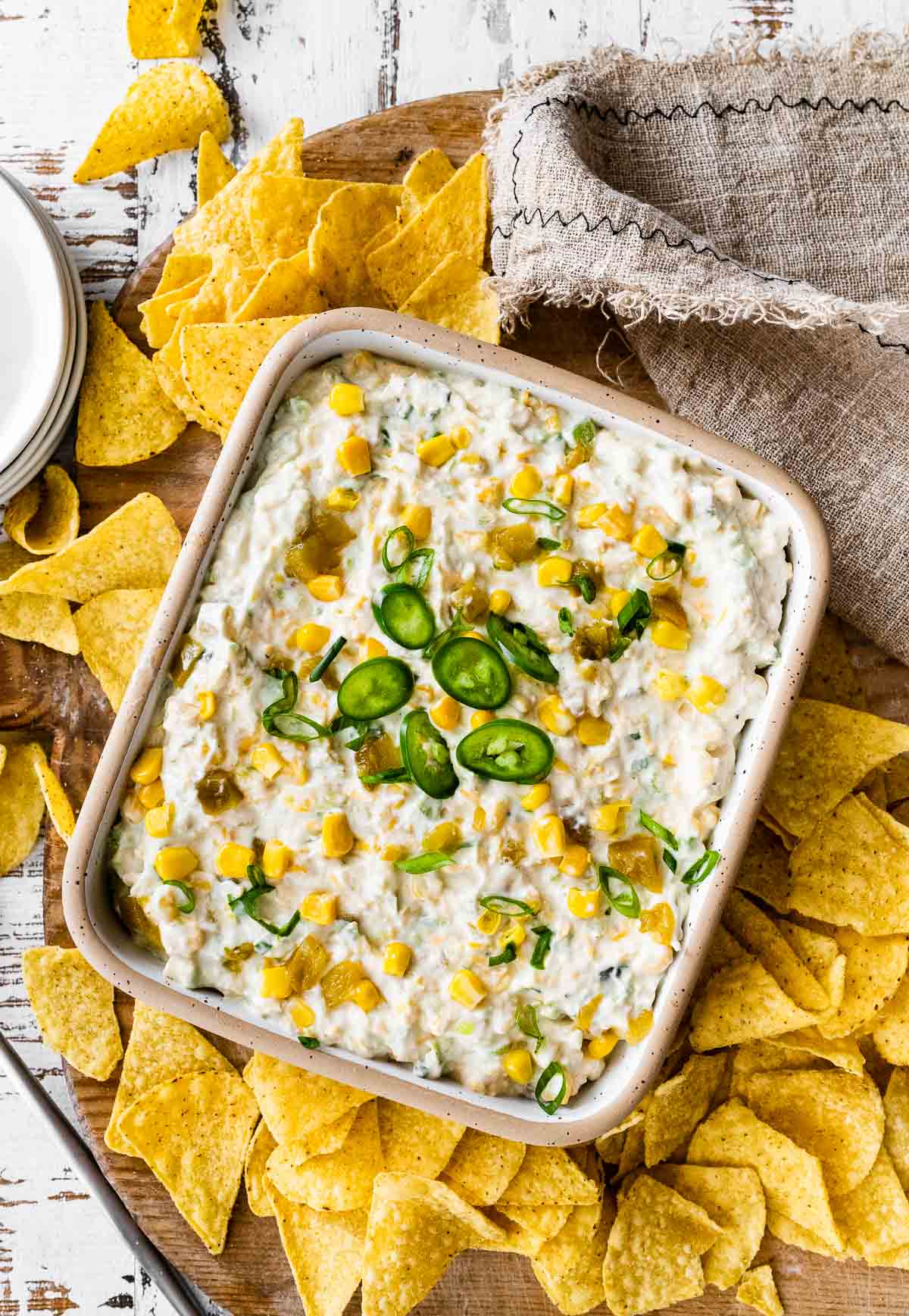 Corn Dip finished dip in serving dish garnished with sliced jalapeno and surrounded by corn tortilla chips