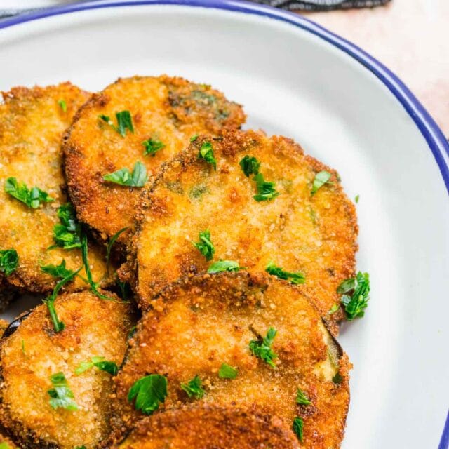 Fried Eggplant cooked slices on plate garnished with parsley