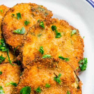 Crunchy eggplant slices on plate garnished with parsley