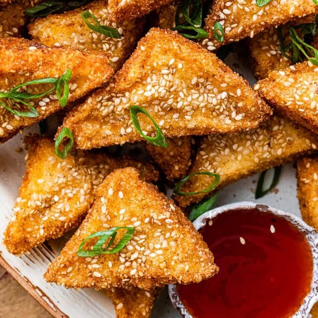 finished triangles of toast on platter with dipping sauce and herb garnish