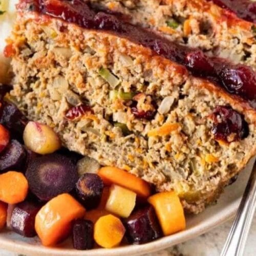 Meatloaf slices in bowl with mashed potatoes and root vegetables