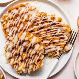 Plate of waffles with drizzle of icing.