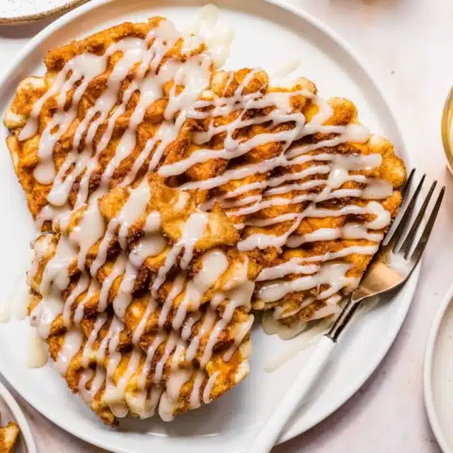 Plate of waffles with drizzle of icing.
