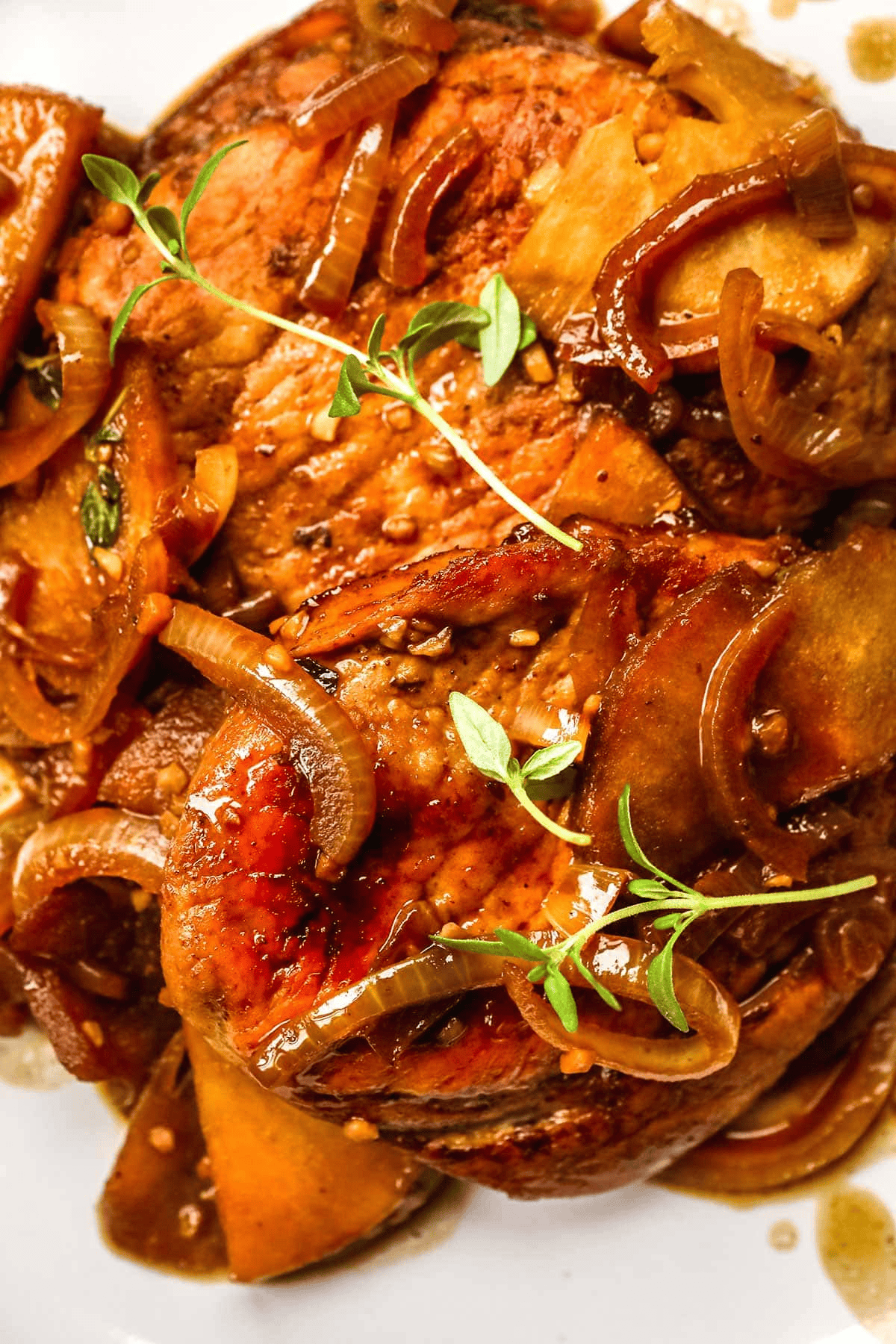 Cooked pork chops with slices of onion and apples