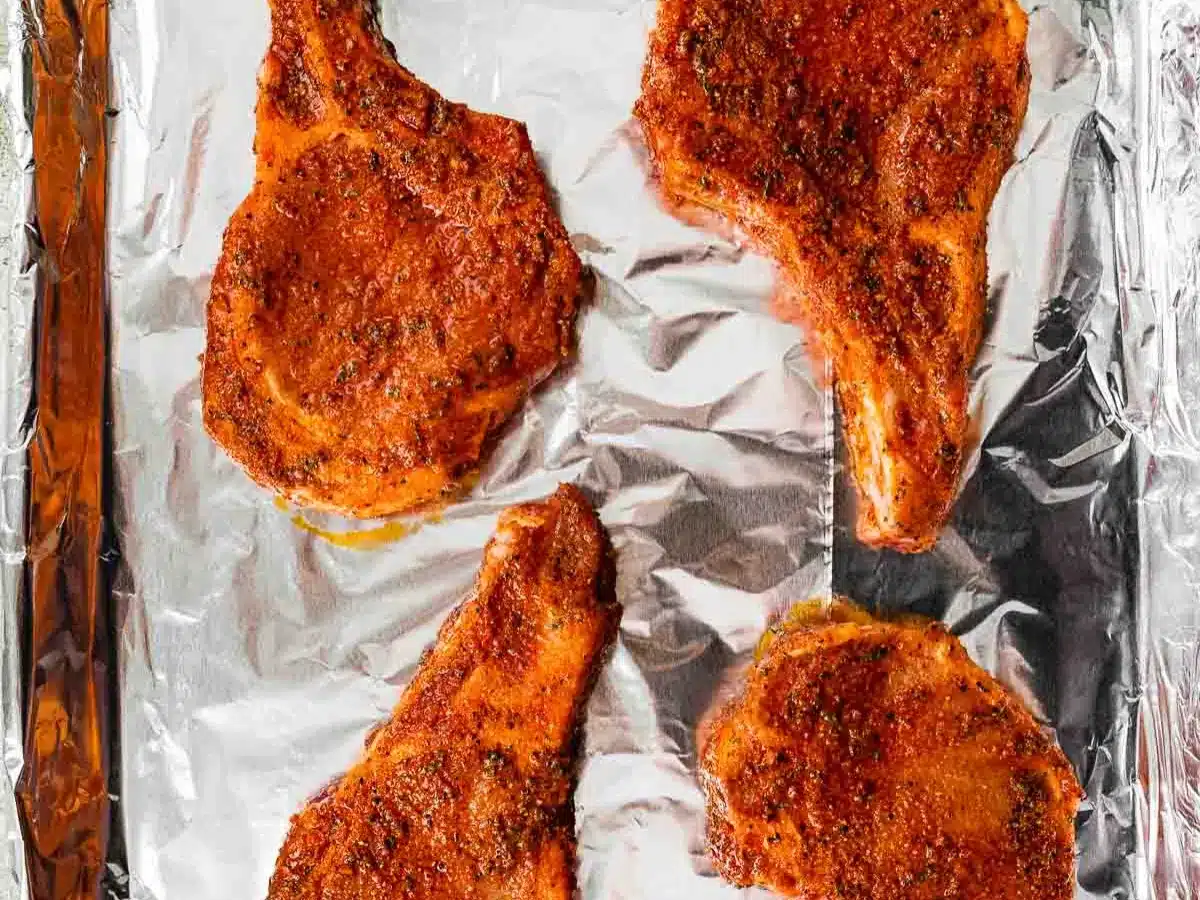 Seasoned pork on foil lined baking sheet.