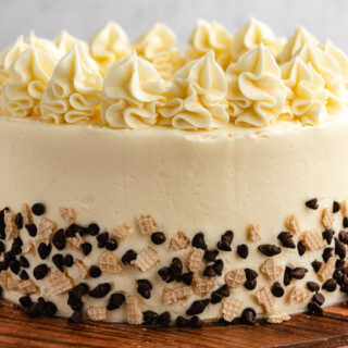 Whole decorated cannoli flavored cake on serving plate.