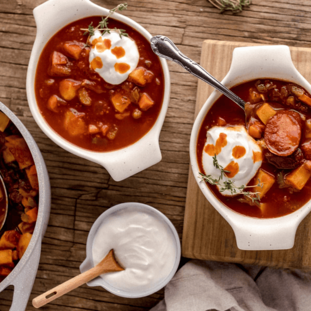 bowls of soup on tables with sour cream on side