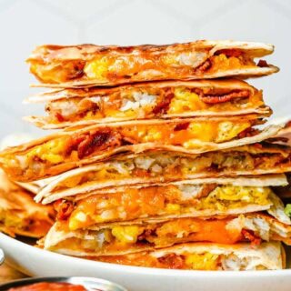 Stacked quesadilla wedges on plate.