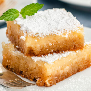 Butter Cake on a plate with a fork and topped with powdered sugar. 4x3