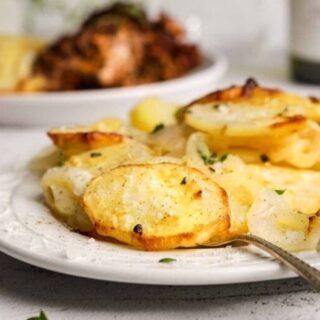 Potatoes on a serving platter with a spoon.