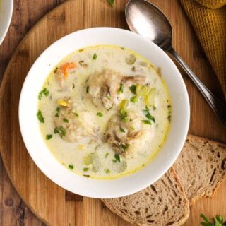 bowl of soup with spoon and bread aerial view