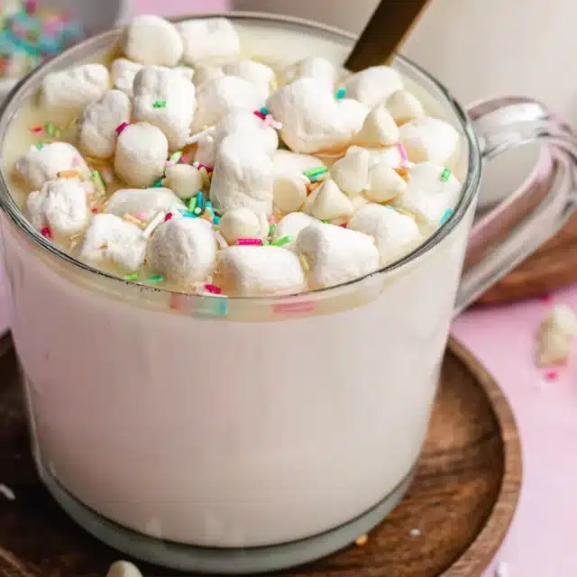 Hot, sweet and creamy beverage topped with sprinkles and whipped cream.