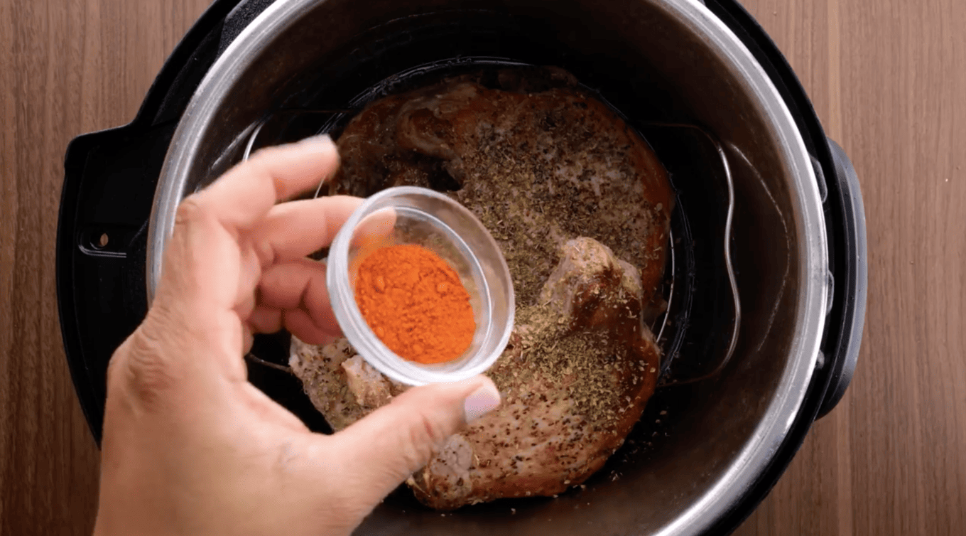 adding paprika to pork chops in an Instant Pot