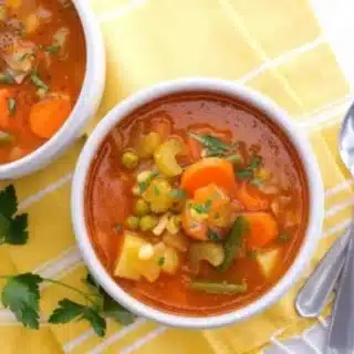 Bowl of red soup with chopped vegetables