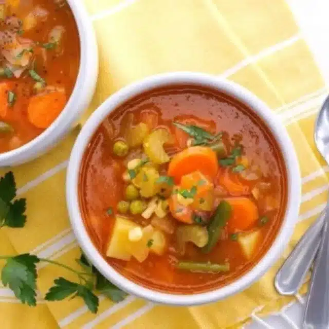 Bowl of red soup with chopped vegetables