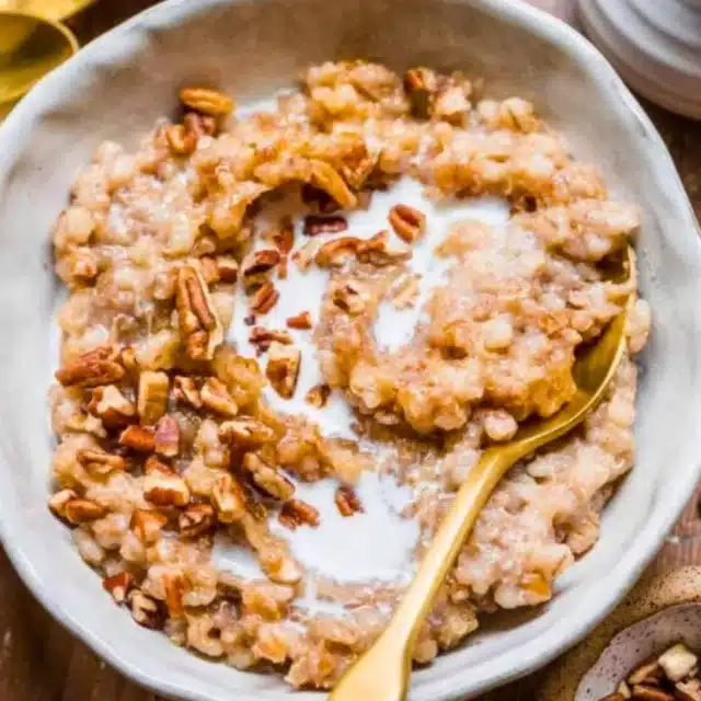 Bowl with grains, nuts, and milk with spoon