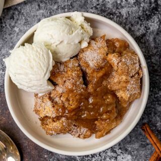Cobbler served in a white bowl with two scoops of ice cream