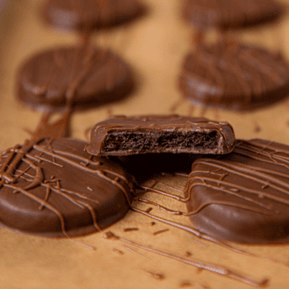 Cool Cocoa Cookies on a baking sheet with one bitten in half on top of two other cookies